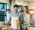 Happy, couple and cleaning with bottle in kitchen for hygiene, teamwork and support in maintenance. Man, woman and smile with detergent at home for bacteria removal, housekeeping and help in marriage