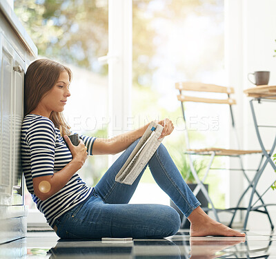 Buy stock photo Woman, newspaper and reading on kitchen floor with coffee, global headlines and thinking in home. Person, press and print media with information for international news story in morning at apartment