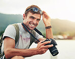 Camera, portrait and photographer man in nature for sightseeing, tourism or travel outdoor. Holiday, photography and vacation with happy tourist at lake or water for hobby, leisure or memory
