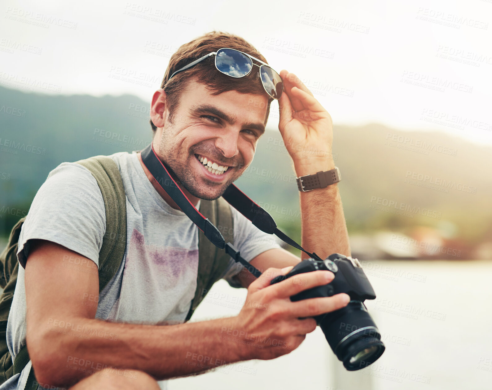 Buy stock photo Camera, portrait and photographer man in nature for sightseeing, tourism or travel outdoor. Holiday, photography and vacation with happy tourist at lake or water for hobby, leisure or memory