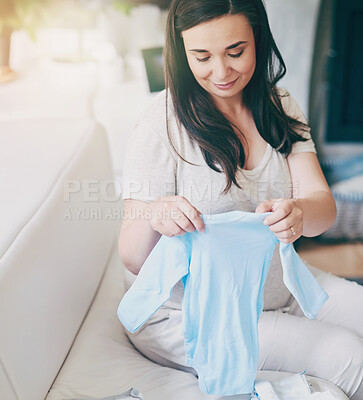 Buy stock photo Pregnant, woman and happy with clothes on sofa for newborn attire or apparel, folding and organizing for arrival of baby. Mother to be, vest and garments for wardrobe in home and ready for motherhood