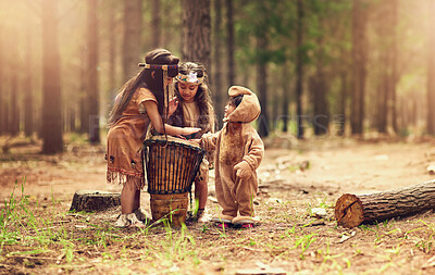 Buy stock photo Native American children, drum and happy for music with playing, bonding and connection in woods. Siblings, kids and instruments with culture, heritage and history in forest with family in California