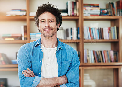 Buy stock photo Happy man, portrait and freelancer with confidence for ambition, knowledge or positive mindset at home. Handsome male person, young author or writer with smile and arms crossed by bookshelf at house