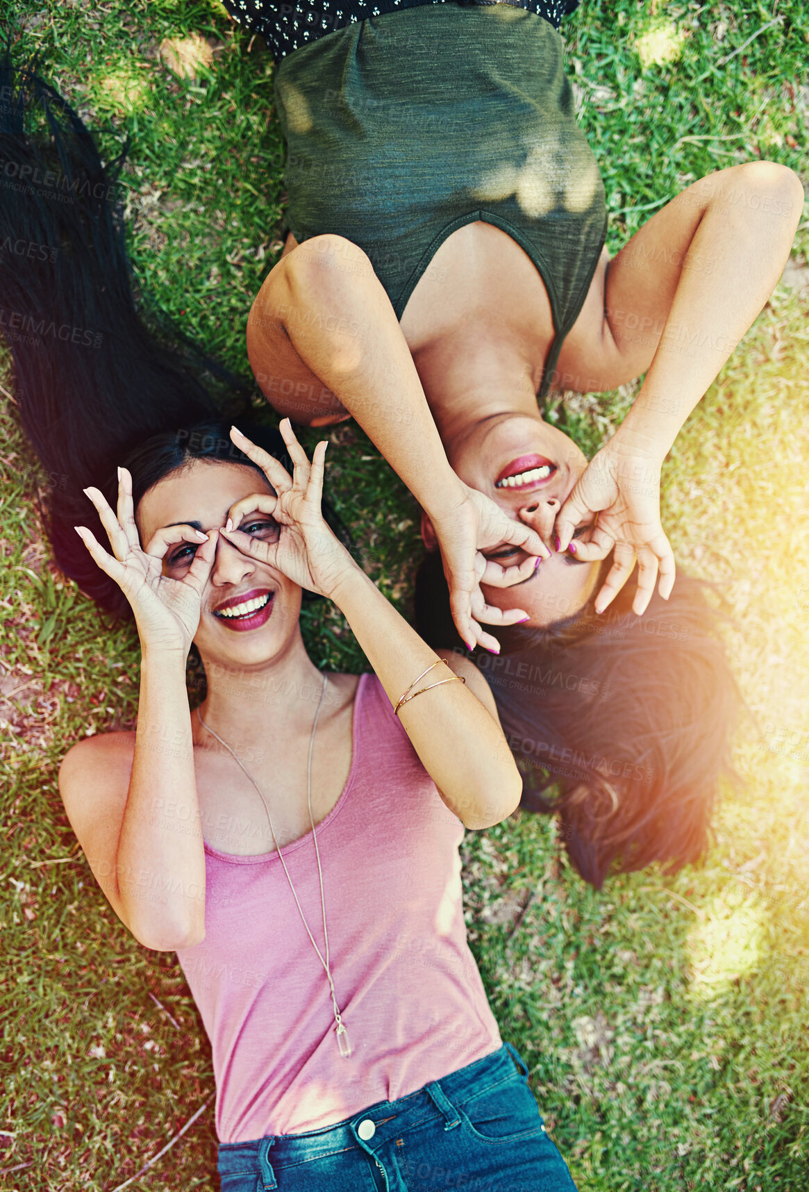 Buy stock photo Above, friends or women lying on grass in nature for relaxing, resting and bonding together. Hands gesture, girls and outdoor for chilling, freedom and peace with happiness and smile in park