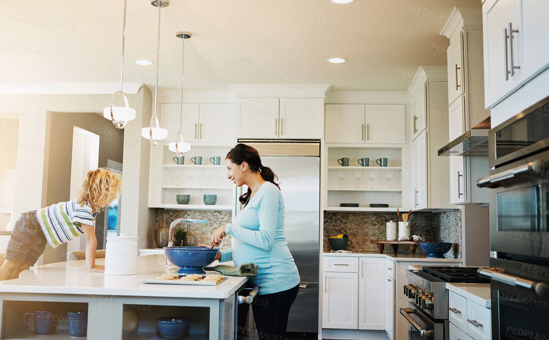 Buy stock photo Mom, kid and pregnant in kitchen with baking in smile for bonding, love and support for child development. Parent, family and happy at home with cookies for fun, enjoy and relax together for memories