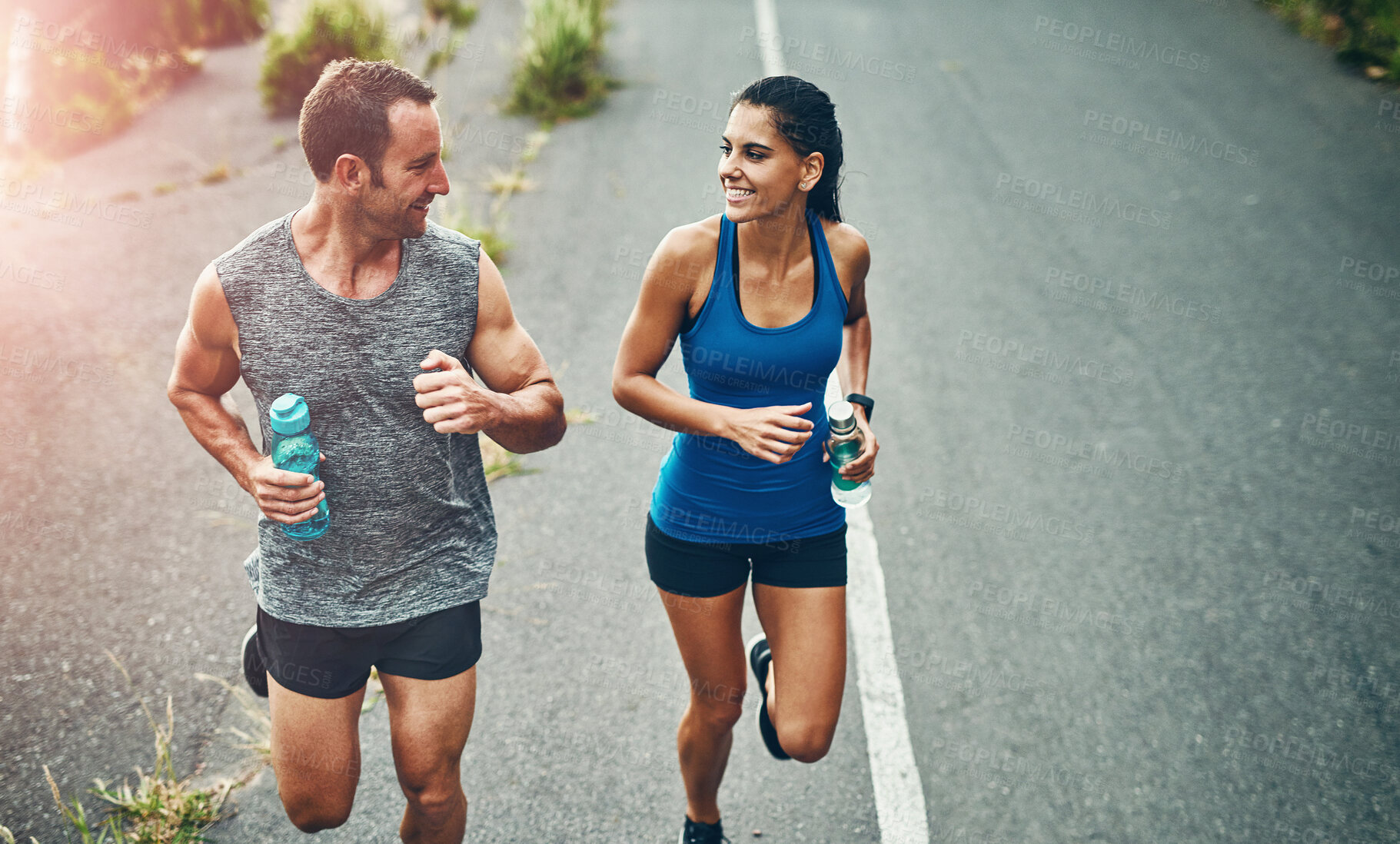 Buy stock photo Fitness, running and couple with smile, exercise and bottle for hydration with water and outdoor. Road, race and people in morning, sportswear and training together, energy and workout in routine