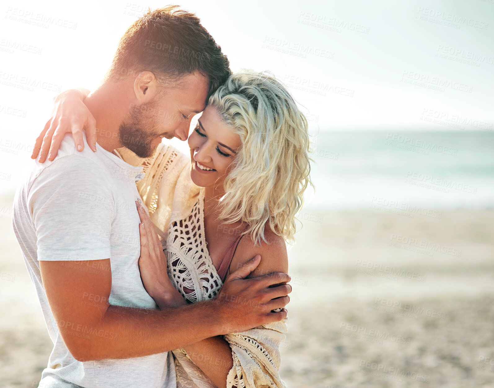 Buy stock photo Happy, couple and hug on beach with love for seaside romance, serene seascape and ocean view with affection. Man, woman and together for bonding by coast on weekend date, embrace and mockup with care