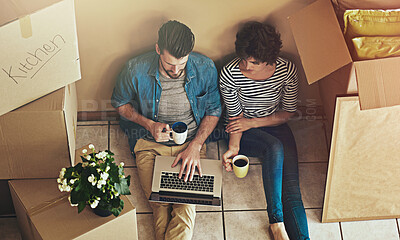 Buy stock photo Box, laptop and couple with coffee in new home for real estate, property website or investment. Floor, woman and man with technology in high angle for house, renovation idea and digital mortgage plan