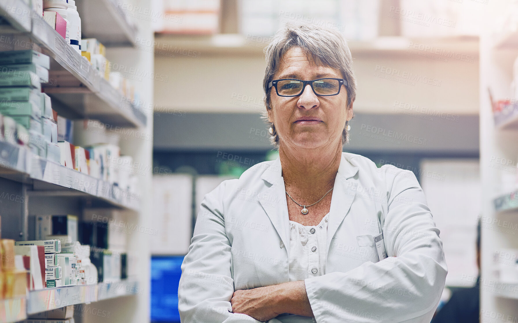 Buy stock photo Mature, pharmacist or portrait of woman with arms crossed in healthcare clinic, pharmacy or drugstore. Proud, wellness or confident doctor by shelf for medication, pills or medicine ready to help