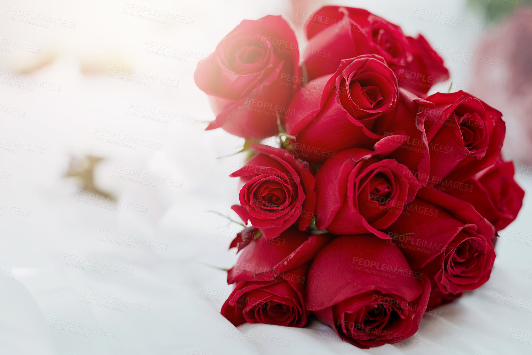 Buy stock photo Home, bedroom and bunch of red roses, sunshine and lens flare with flora, summer and decoration. Empty, love and bed with flowers, sunlight and nature with gift, present for Valentines day or bouquet