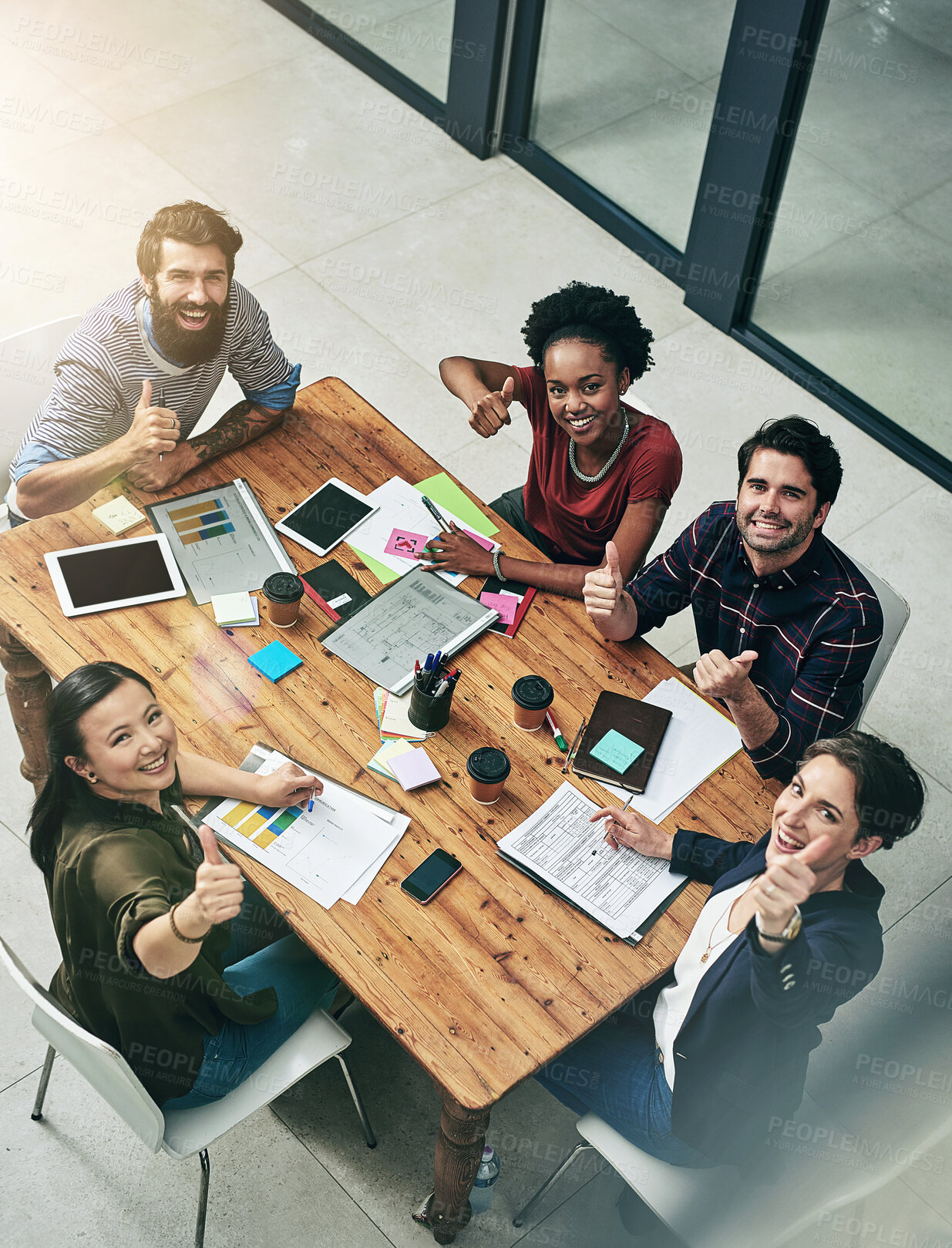 Buy stock photo Portrait of business people, thumbs up and documents in office for planning, subscription or goal. Above, lens flare and diverse staff with hand gesture for briefing, growth or graphs at publication