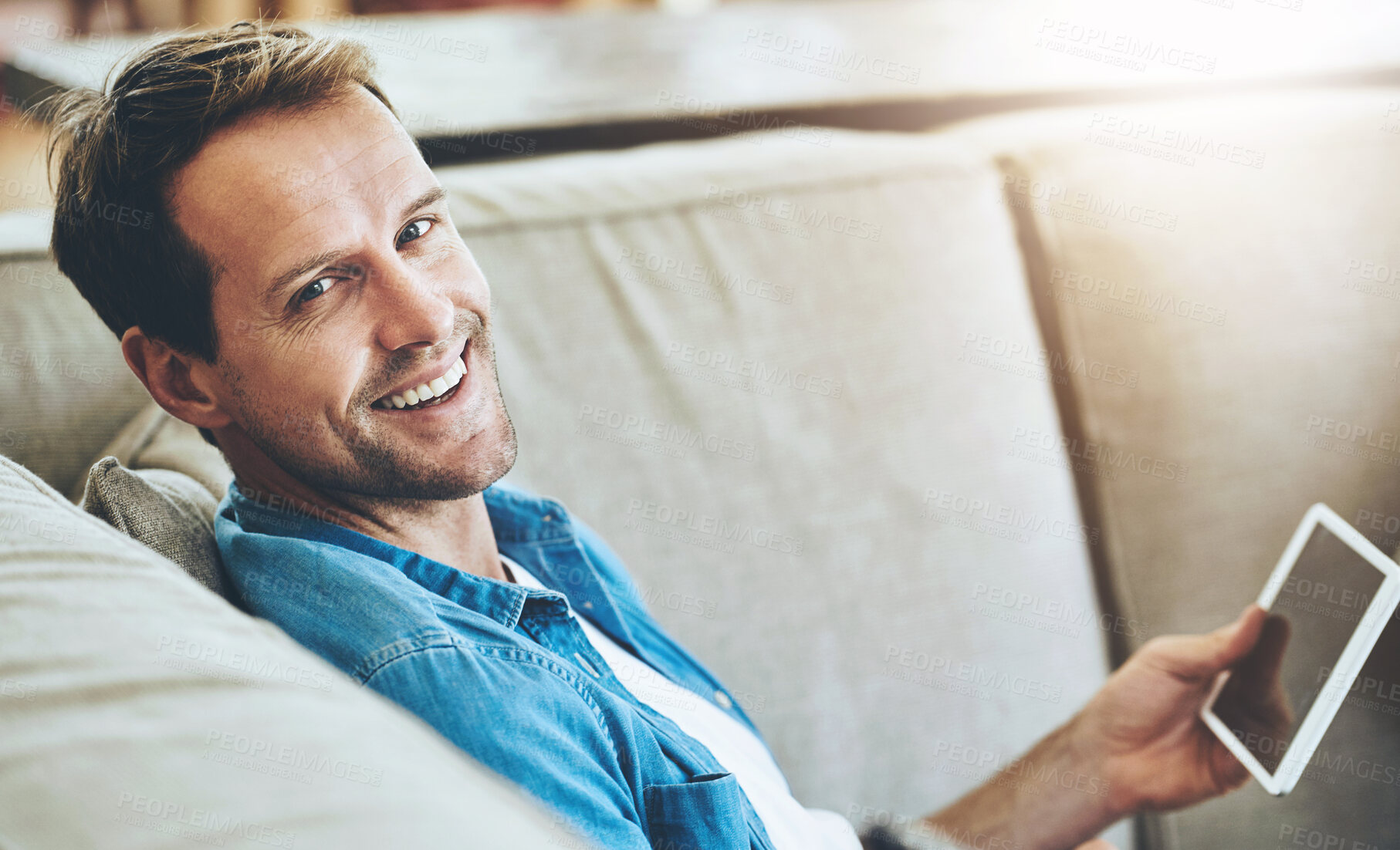 Buy stock photo Man, portrait and happy on sofa with tablet for online movie streaming in living room with technology. Internet, couch and digital game for entertainment on weekend or break in Germany with screen.