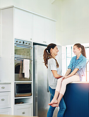 Buy stock photo Mother, daughter and bonding with kitchen, talk and gossip for love and parenting. Family, smile and happiness with home, discussion and conversation for care and child chat together for relaxing