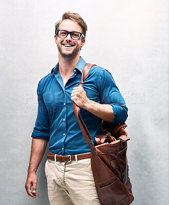 Buy stock photo Businessman, portrait and studio with bag for fashion or work gear, smart casual for style with smile. Male accountant, backdrop and happiness for clothes with glasses, cool or wellness in Chicago