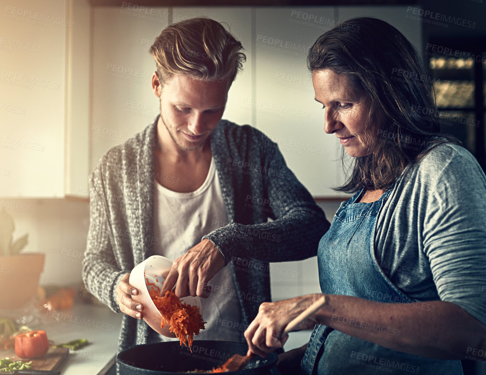 Buy stock photo Mature, mother and son with cooking in kitchen for bonding, support or helping with vegetables for dinner. Family, woman or man in home with preparation for healthy meal, nutrition or hungry in house