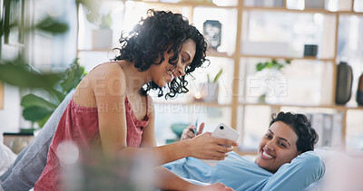 Buy stock photo Phone, lesbian couple and laughing at meme, social media or funny video in living room of their home. Lgbt, happy girls and bond with joke on smartphone while relaxing on sofa in lounge for happiness