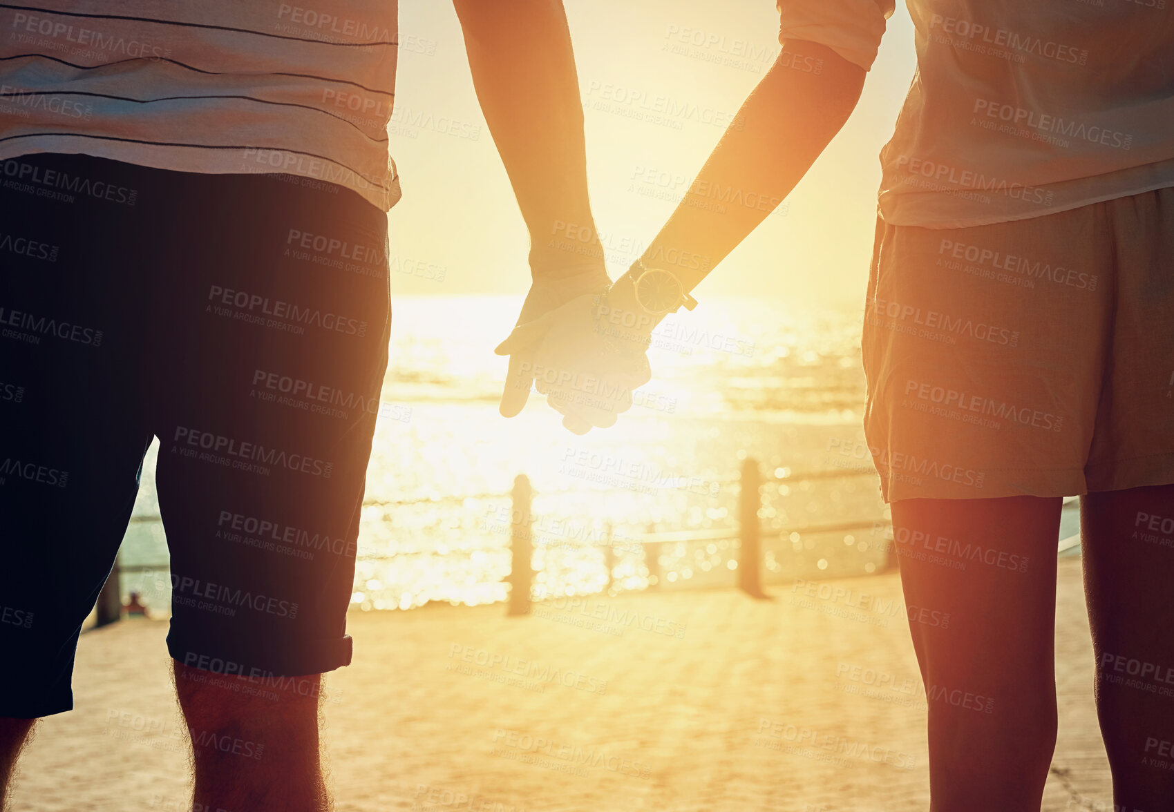 Buy stock photo Beach, holding hands and couple with love, sunshine and vacation for honeymoon, romance and travel. Closeup, seaside and man with woman, lens flare and adventure with support, summer and journey