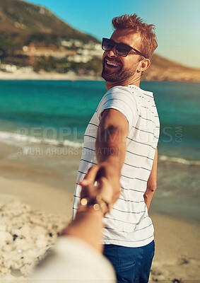 Buy stock photo Man, smile and holding hands with partner by ocean for wellness, travel or vacation with happiness. Happy couple, summer and walking together on beach sand for holiday, peace and trust in Cape Town