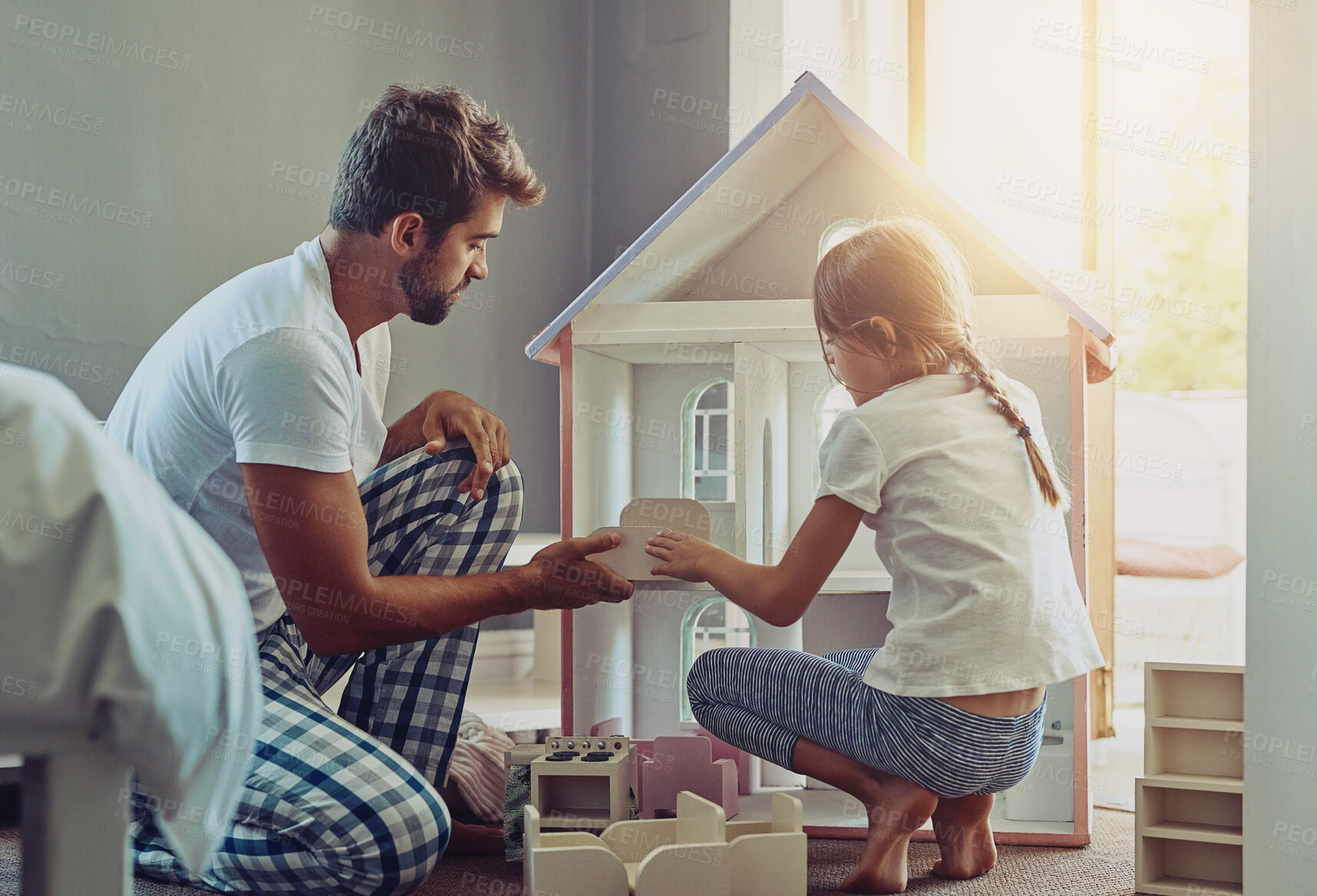 Buy stock photo Father, child and doll house playing in home for morning fun, growth and development. Male person, dad and daughter in living room with lens flare for learning, help with packing toys for bonding