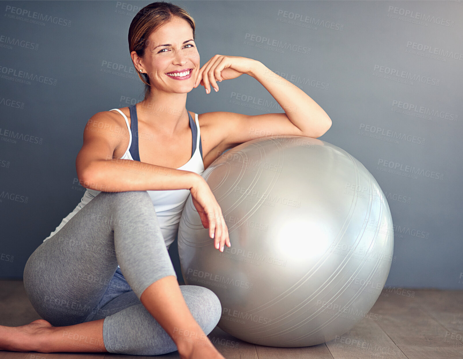 Buy stock photo Ball, fitness and portrait of woman on floor in studio with gray background for workout. Exercise, health or smile and happy person with equipment for physical improvement, training or wellness