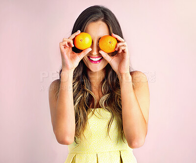 Buy stock photo Happy, orange on eyes and woman in studio for healthy eating, nutrition and detox for wellness. Food, smile and person with fruit for organic diet, wellbeing and natural vitamin c on pink background