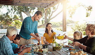 Buy stock photo Happy family, eating and lunch with bonding outdoor on patio with conversation, relax or hosting healthy food. Parents, grandparents and kids at dining table in backyard of home with talking and fun