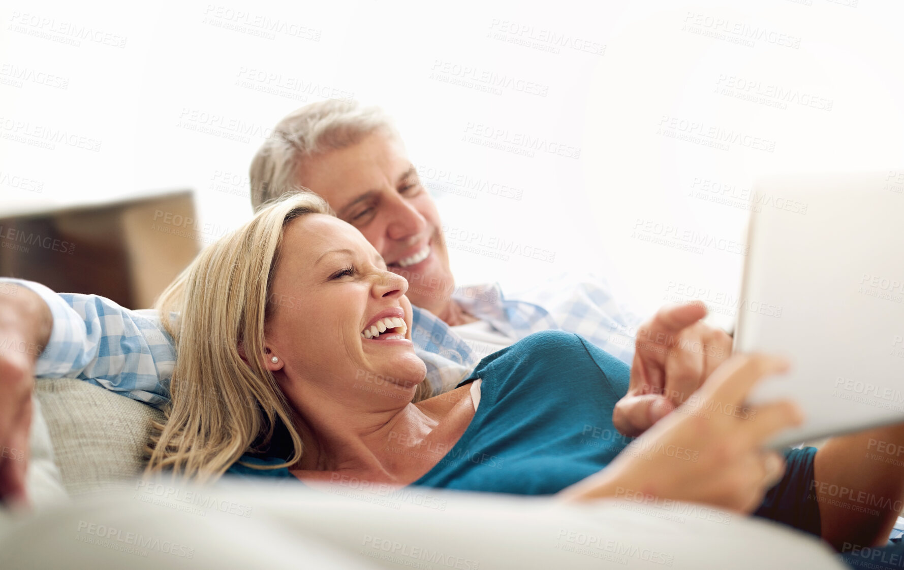 Buy stock photo Relax, couple and smile with tablet on sofa for comedy, online movie and subscription on website. Mature man, woman and laughing with technology at home for entertainment, streaming and funny film