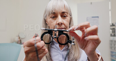 Mature woman, optometrist and frame for eye lens or equipment for examination and vision testing. Closeup, tools and trial for diagnosis or eyesight with assessment, consultation and assistance.
