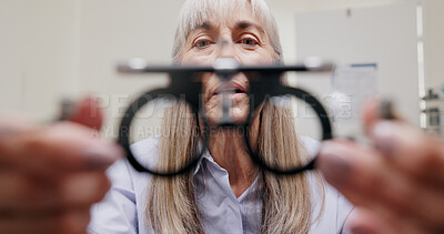 Mature woman, optometrist and frame for eye lens or equipment for examination and vision testing. Closeup, tools and trial for diagnosis or eyesight with assessment, consultation and assistance.