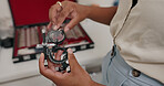 Eye care, hands and person in store for glasses, vision and optometry, choice and decision for eyewear. Closeup, shop and option of spectacles, product and customer or client with lens on sale