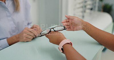 Glasses, frames and patient at counter by employee in clinic for vision, prescription and eye care. optometrist, healthcare and lens or health for eyes, glaucoma and ocular diseases or eyesight