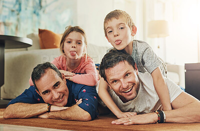 Buy stock photo Gay parents, family and children in portrait with love, care and funny face on living room floor at home. Happy father and kids for weekend, bonding and relax together with tongue out, fun and games