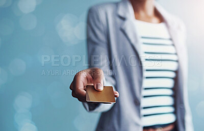 Buy stock photo Hand of woman holding credit card for banking, shopping and buying while standing alone isolated on blue copy space. Fingers of stylish african female paying for purchase on blue bokeh background