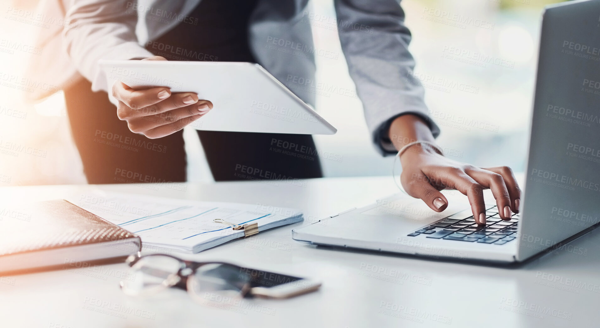 Buy stock photo Business woman working on a laptop and tablet, planning a strategy and browsing the internet for project ideas while working in an office alone at work. Closeup of hands of a corporate executive