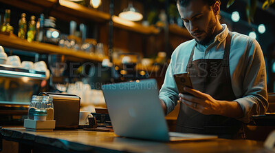 Laptop, phone and barista in coffee shop working at night on stock inventory for startup. Technology, small business and man waiter with cellphone and computer for online website in cafe restaurant.