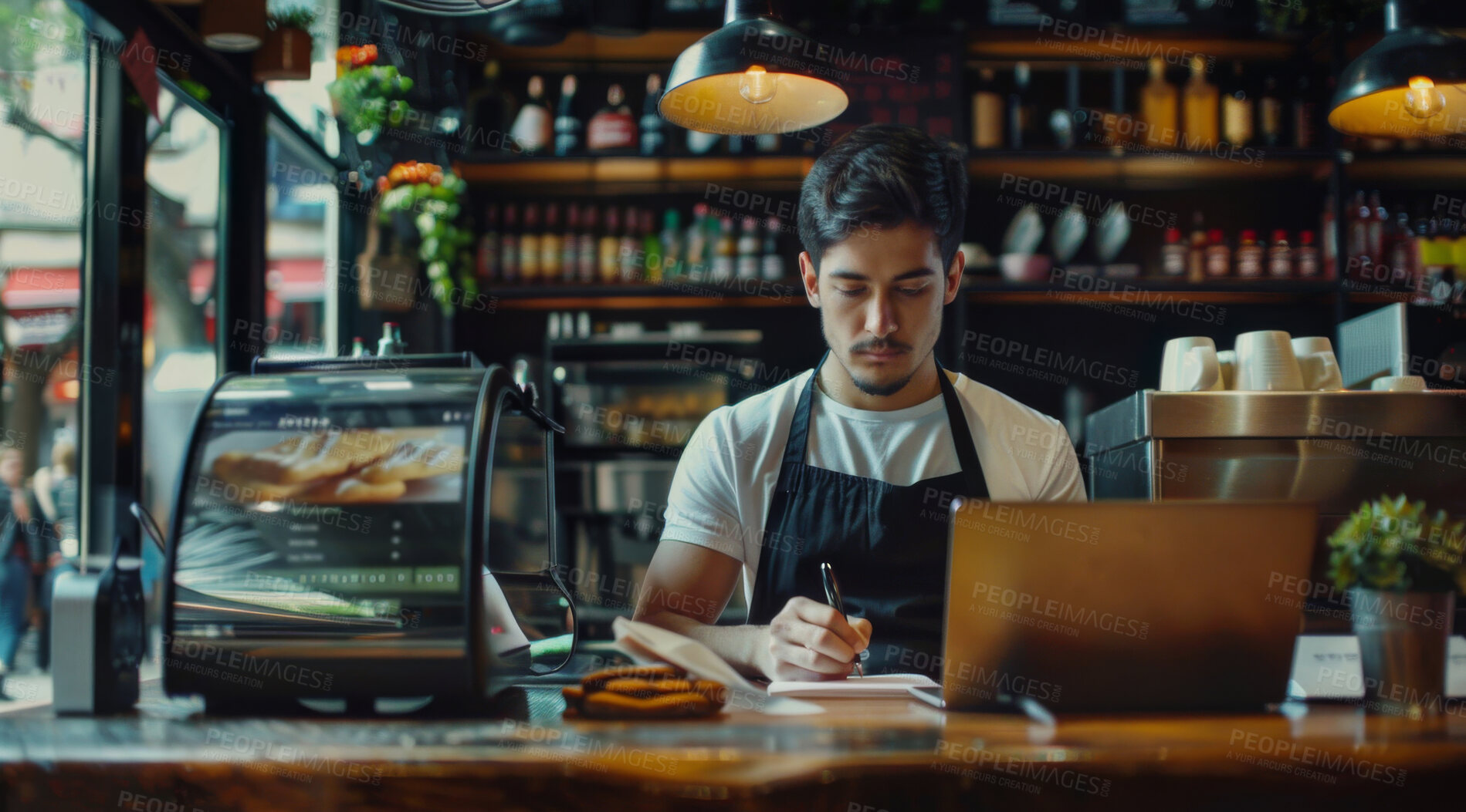 Buy stock photo Laptop, writing and man barista in coffee shop working on stock inventory for startup restaurant. Technology, small business and male cashier with computer for online website with notes in cafe.