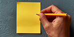 Person, hands and writing with sticky note for agenda, schedule planning or tasks on a dark background. Closeup of planner with empty document, sign or small tab for reminder, checklist or post tips