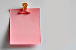 Sticky note, clip and message with reminder for agenda, tasks or post on a white studio background. Closeup of document or pink page with alert, review or memo of sign for notice on mockup space