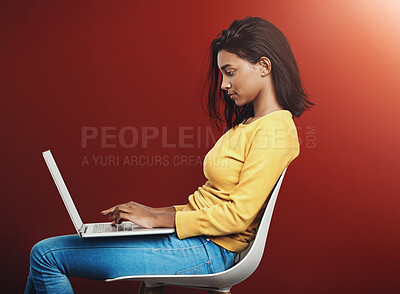 Buy stock photo Typing, chair and woman with laptop in studio for school project, knowledge or browsing internet on red background. Profile, student and Indian person for education, history paper or learning mockup