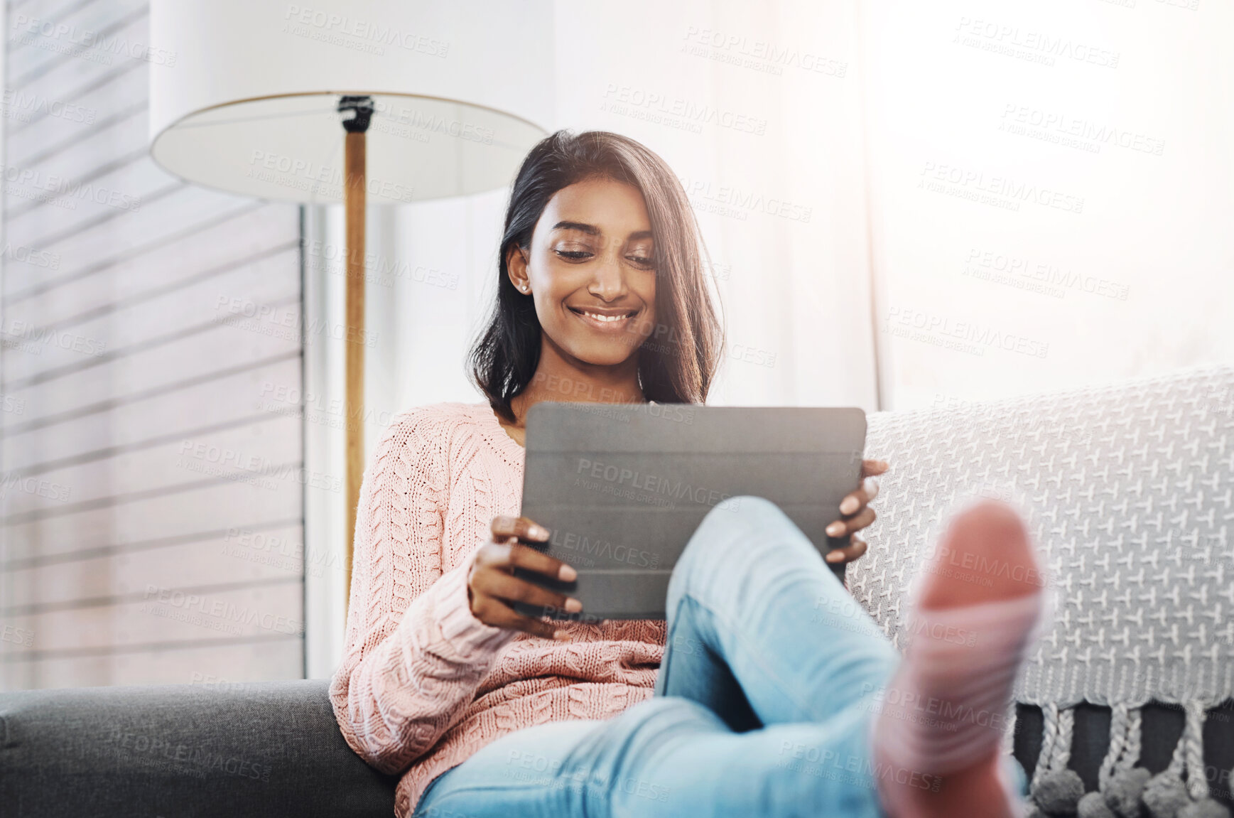 Buy stock photo Indian woman, tablet and relax on sofa in home with movie streaming, web subscription and watching series. Happy girl, person or digital app for online shopping, social media scroll or video download