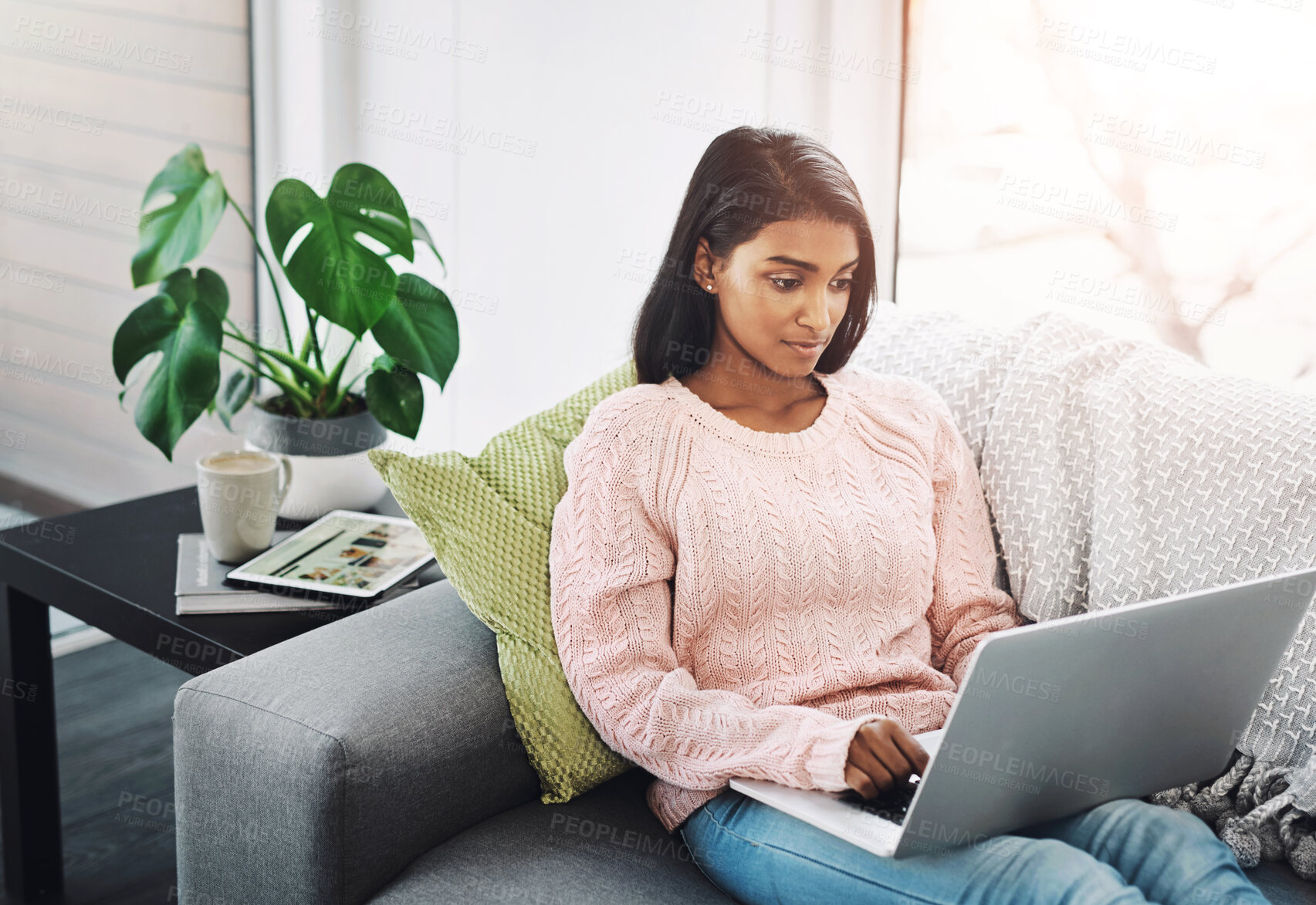 Buy stock photo Woman, laptop and typing on home sofa for student research, streaming or social media. Indian female person on a couch to relax, surfing internet or writing email for communication on website