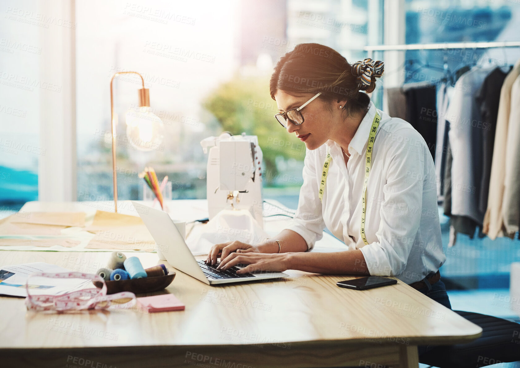 Buy stock photo Fashion designer, woman and typing on laptop in shop for email, project or online order of fabric in creative startup. Serious tailor, computer and small business for clothes or 
textile in boutique