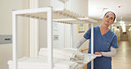 Hospital, clean and towels from laundry with nurse and cart for cloth, medical and hygiene with healthcare. Nursing home, hallway and caregiver with fabric for wellness, rehabilitation and uniform