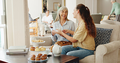 Buy stock photo Senior mother, daughter and coffee in retirement home with conversation, visit or chat on sofa in morning. Women, relax and drink with tea cup, care and bonding for connection at breakfast in lounge