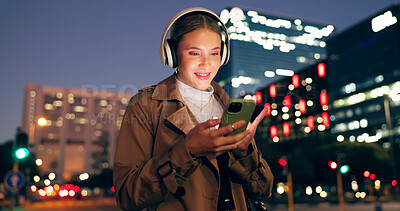 Woman, outdoor and smile on smartphone with headphone for music playlist, entertainment at night in New York. Female person, happy and internet for streaming platform with song or album and video