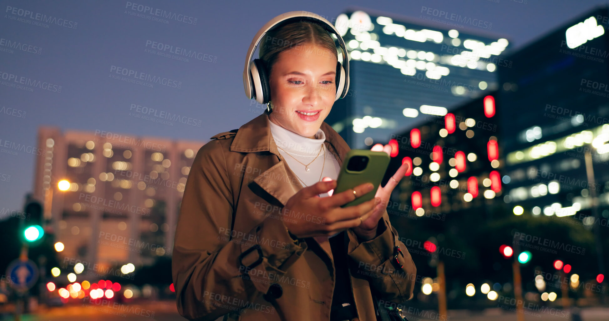 Buy stock photo Woman, outdoor and smile on smartphone with headphone for music playlist, entertainment at night in New York. Female person, happy and internet for streaming platform with song or album and video