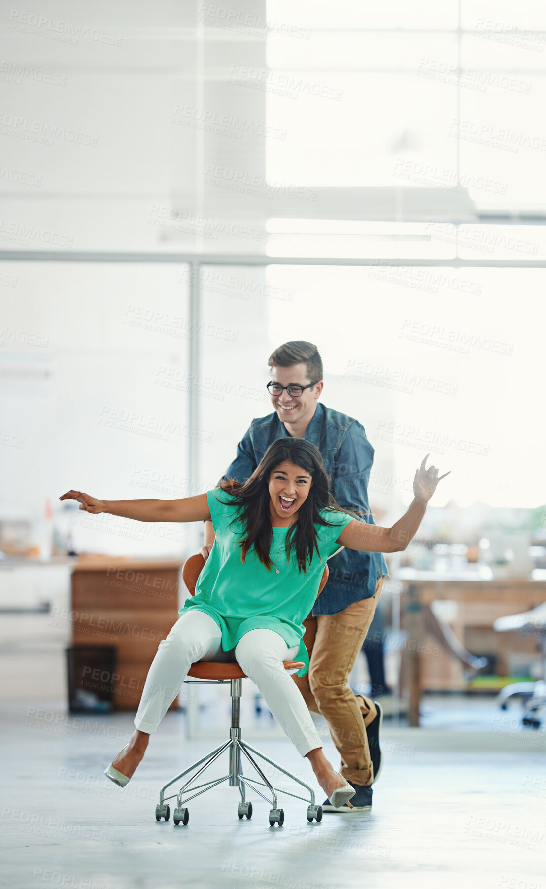 Buy stock photo Office, playing or business women push chair for happiness, investment growth or startup success in company workspace. Smile, fun and people with excited face for celebration, achievement and win