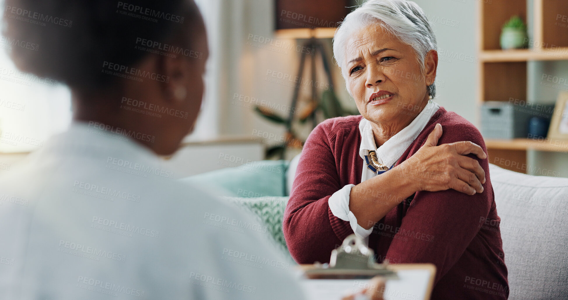 Buy stock photo Senior, woman and doctor with consultation for shoulder pain with injury, explaining symptoms and medical checklist. Elderly patient, nurse and discussion in nursing home, osteoporosis and rear view