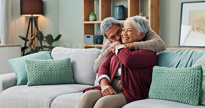 Senior, couple and hug on couch with love for marriage, commitment and safety with security on weekend break. Man, woman and together on sofa for bonding with comfort, close and trust with romance.
