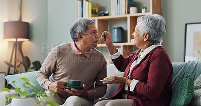 Home, cake and elderly couple with coffee for love, bonding and funny conversation on sofa. Senior people, happy and relax with dessert for afternoon communication, discussion and peace in retirement